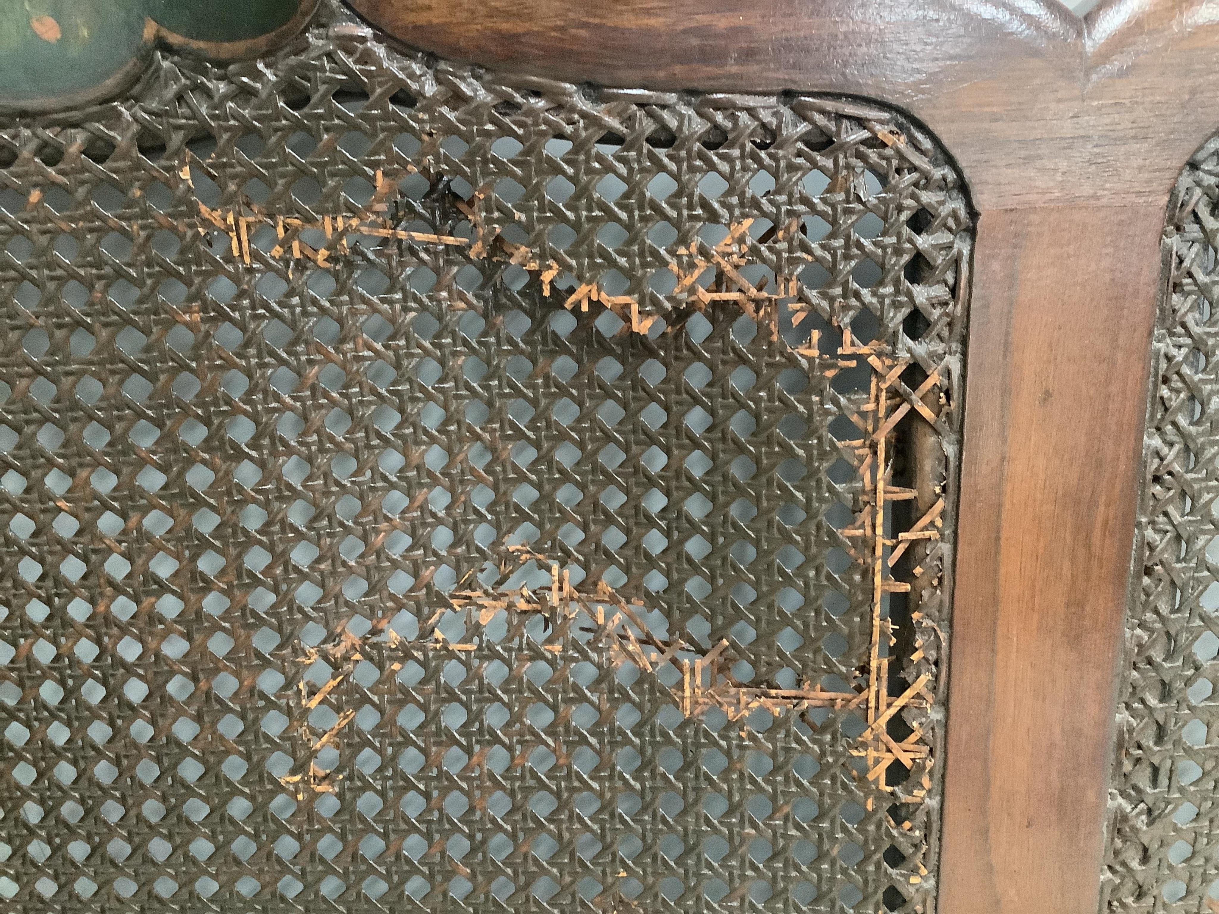 An early 20th century part painted walnut three piece bergere suite, settee width 186cm, depth 78cm, height 80cm. Condition - fair, although one cane panel is damaged and needs repair